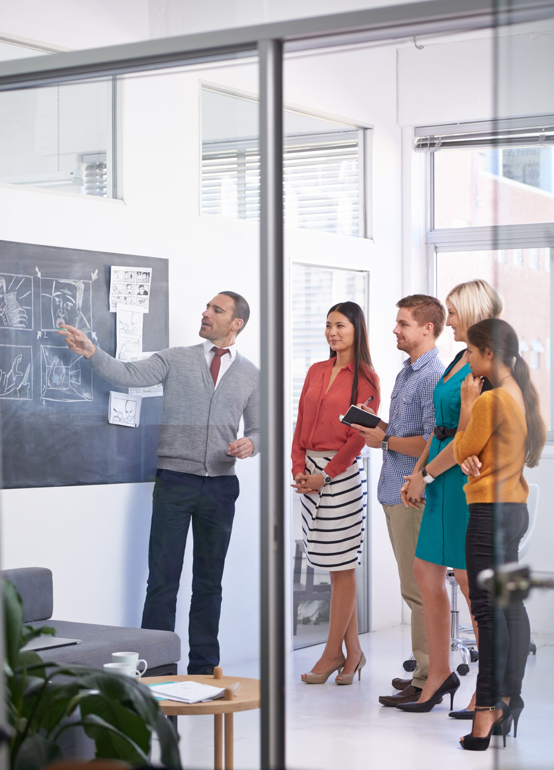 creative-man-chalkboard-coaching-with-team-storyboard-development-meeting-office-speaker-talking-group-employees-project-planning-production-presentation-startup